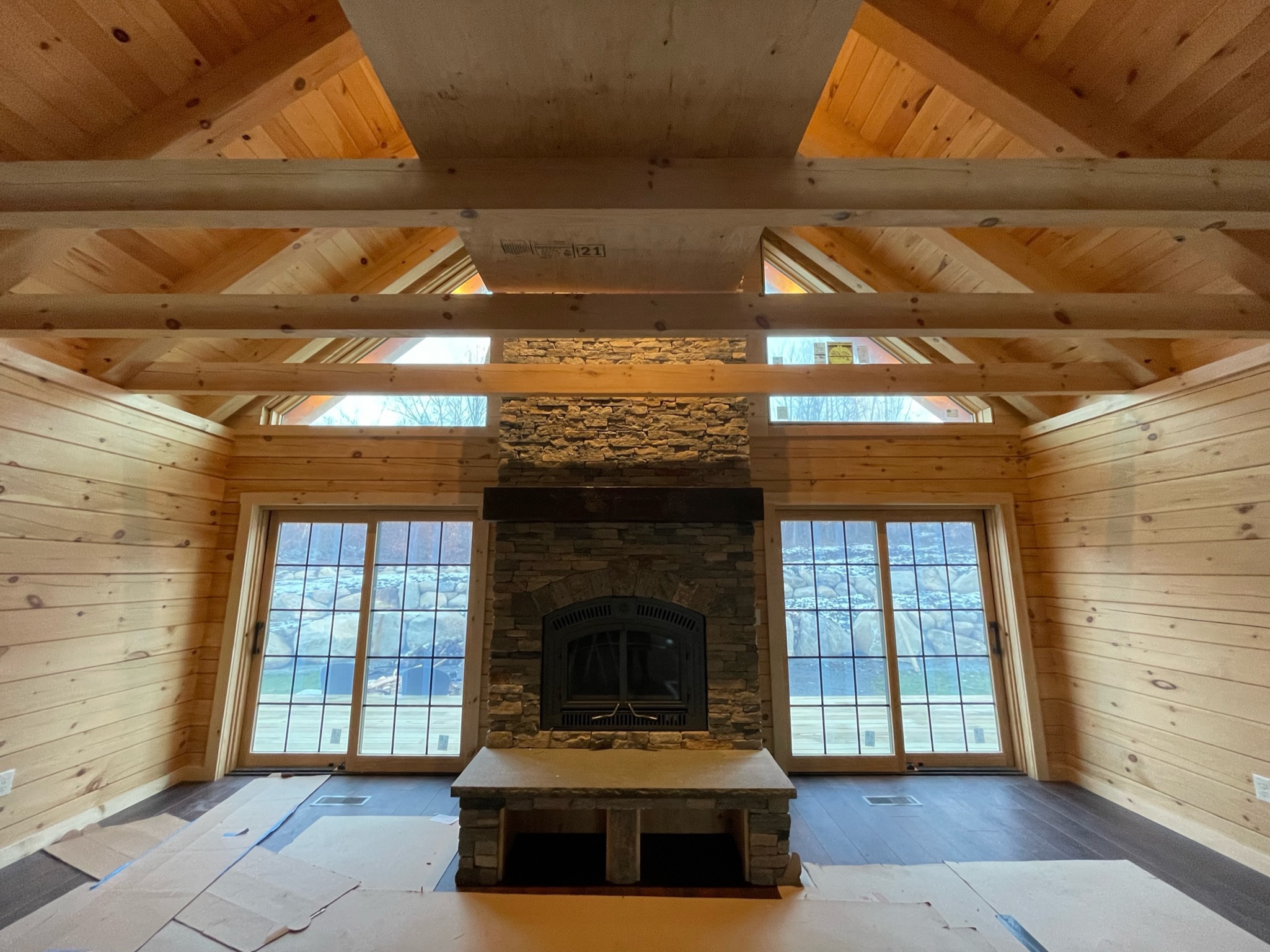 Custom log home great room with cathedral ceiling and stone fireplace