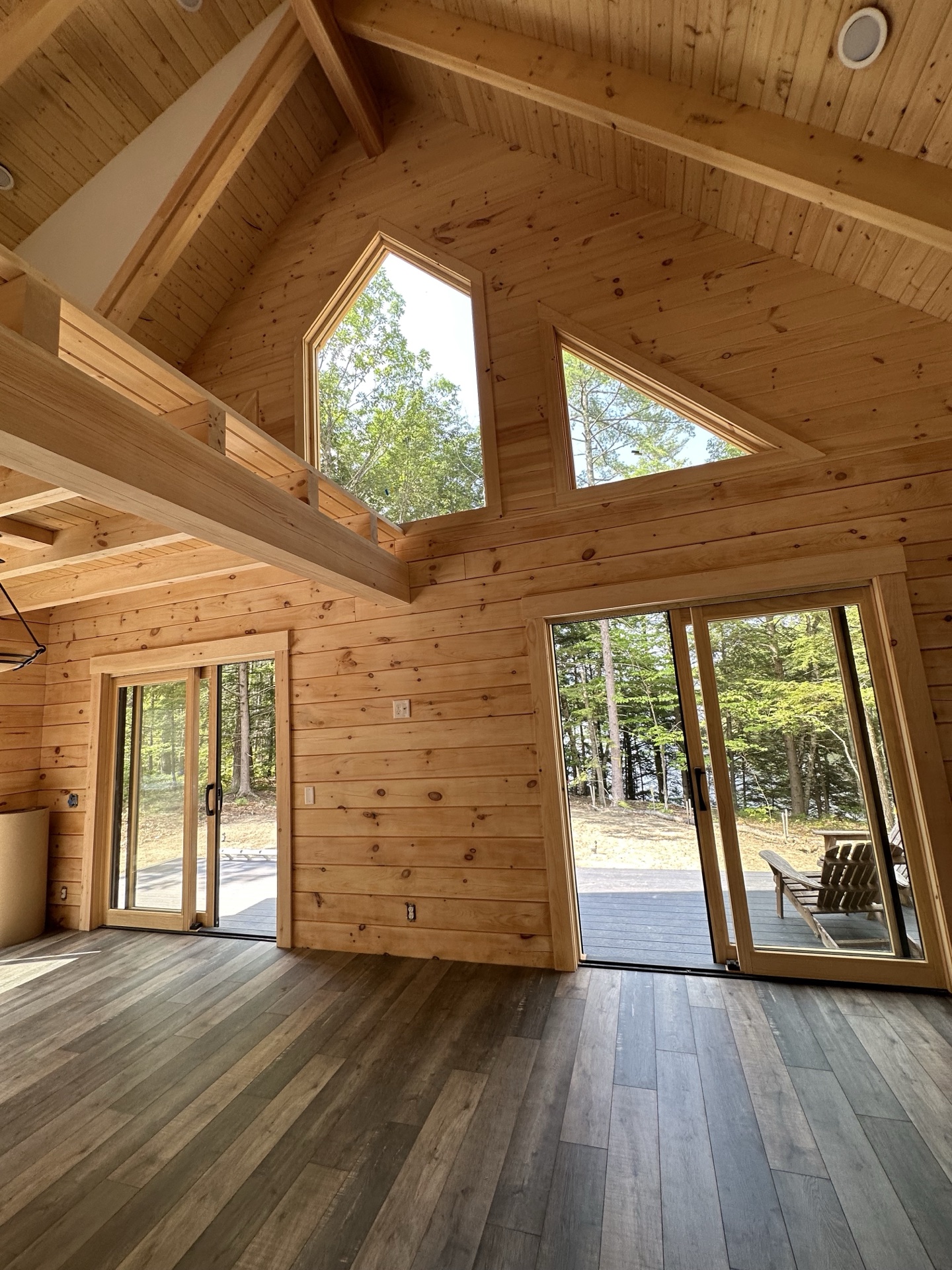 Freedom log home interior with cathedral ceiling, hexagonal window, and large sliding doors