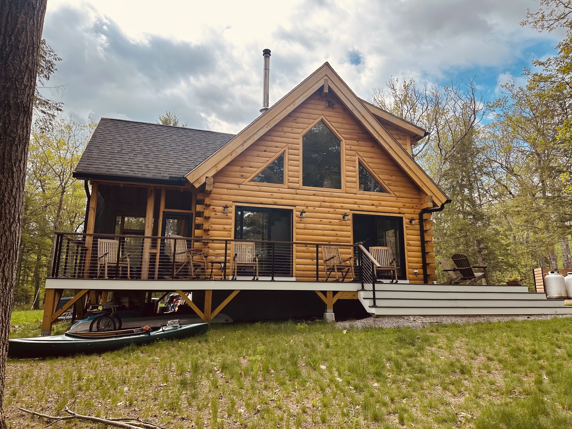 The Freedom model log home with its full-length deck and roof overhangs, the kind of details that keep water off the log walls and keep maintenance low