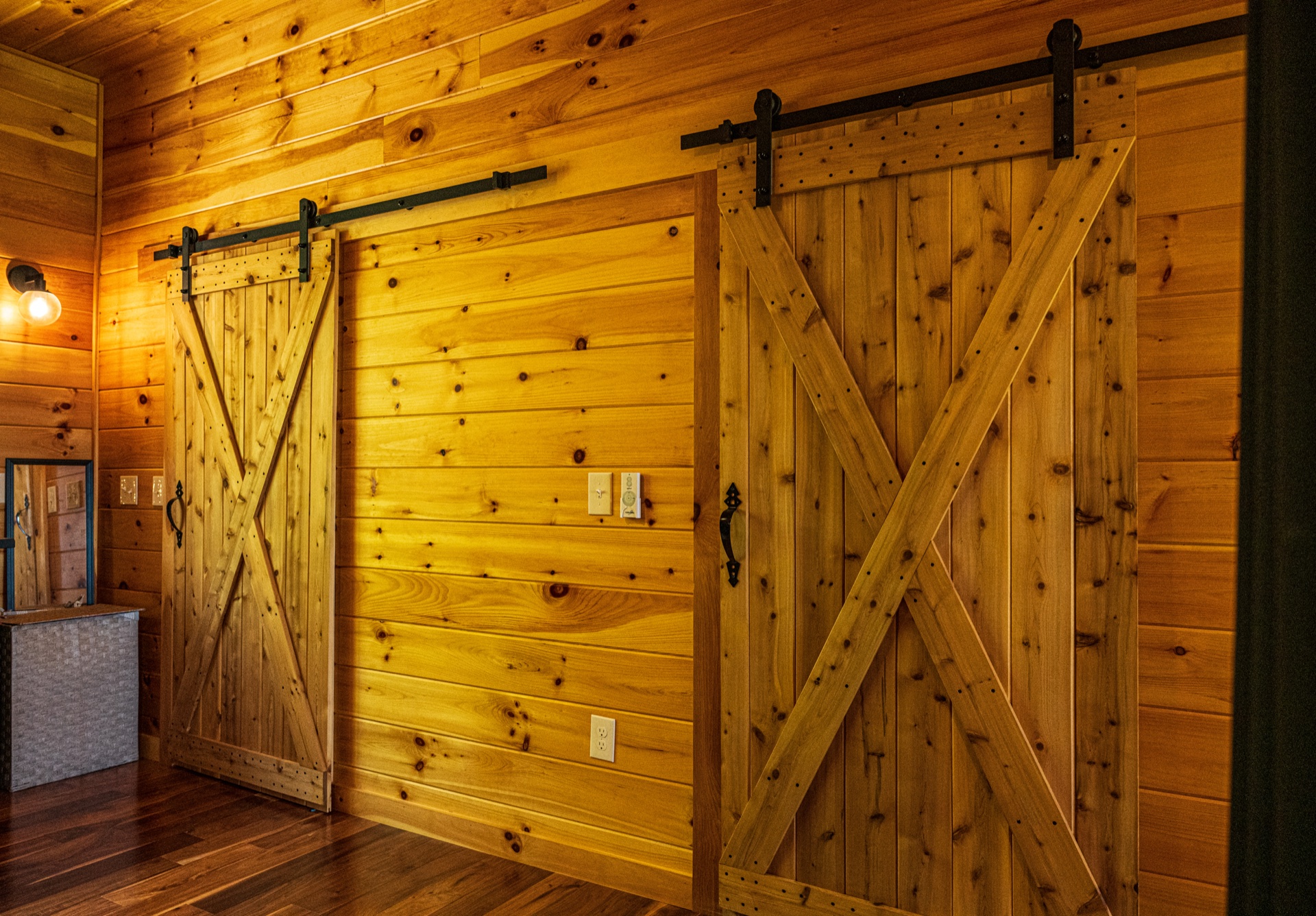 Pair of rustic sliding barn doors on Eastern White Pine wall in the Ossipee log home