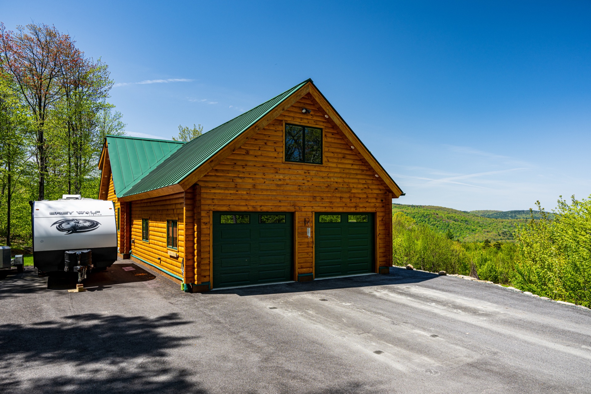 Ossipee detached garage with matching green metal roof and double bay doors