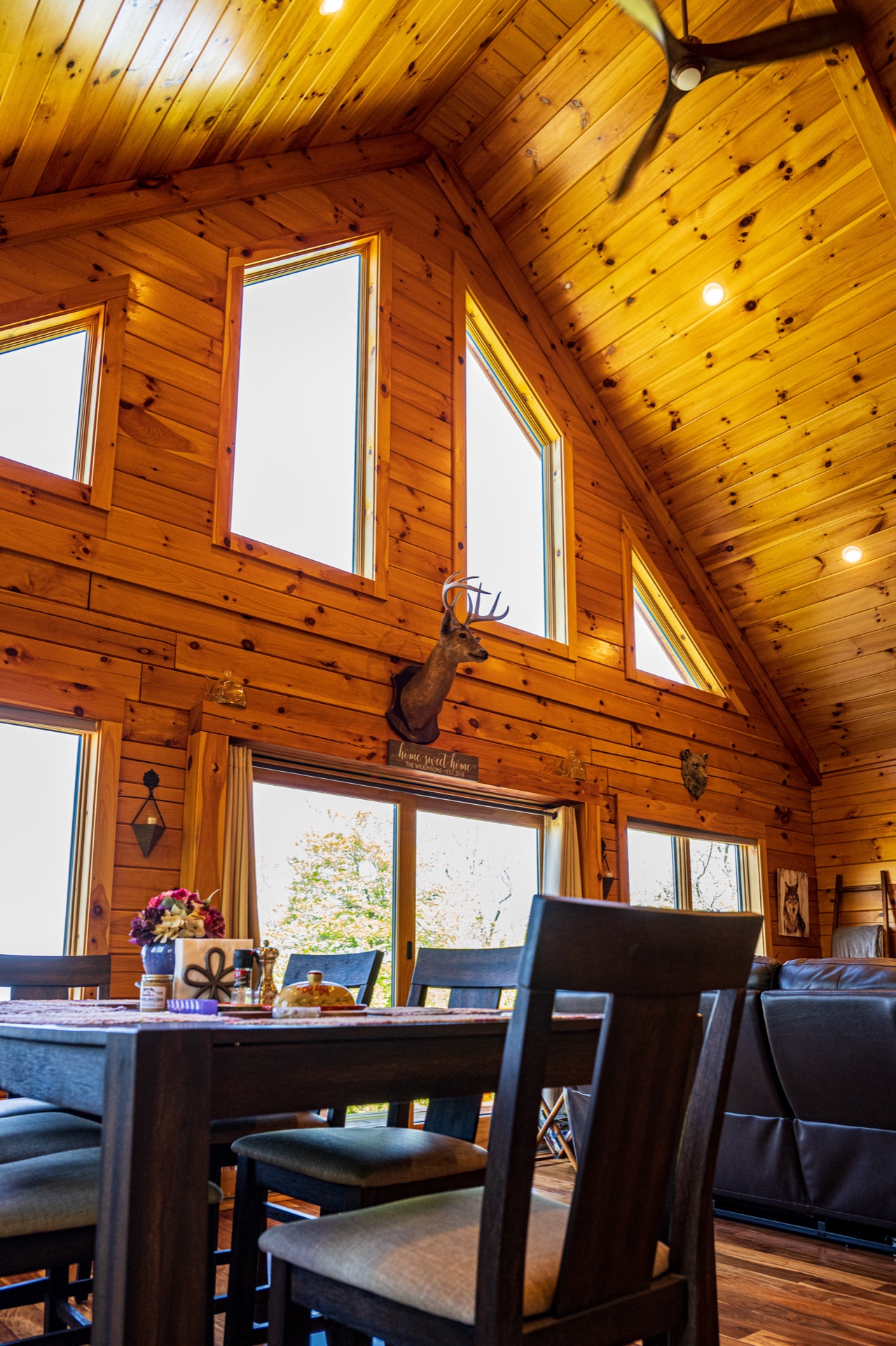 Ossipee dining area with chalet windows, deer mount on log wall, and family-style table