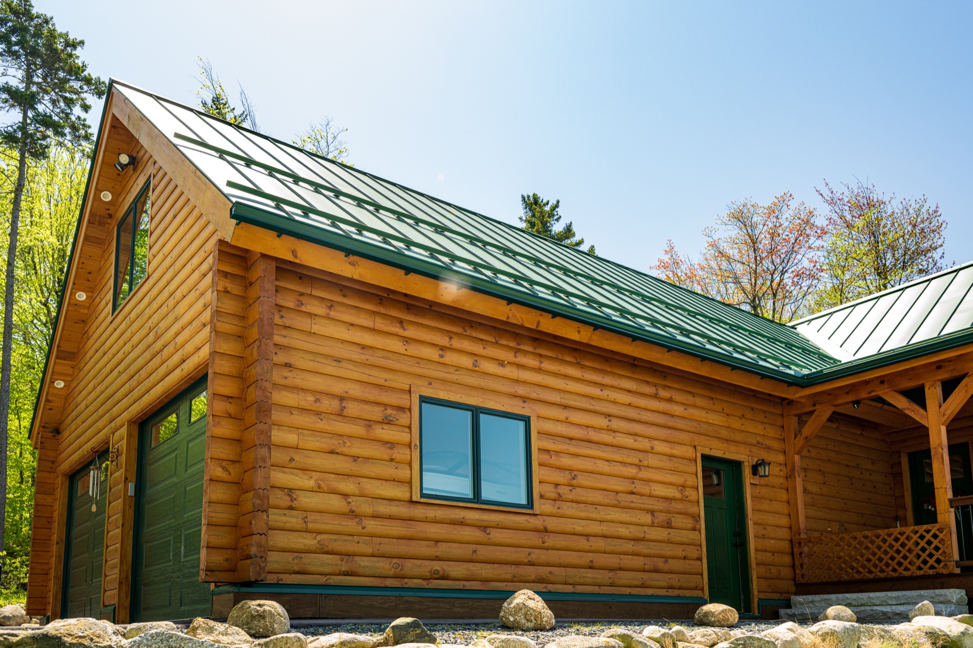 The Ossipee log home attached garage with green metal roof and matching trim