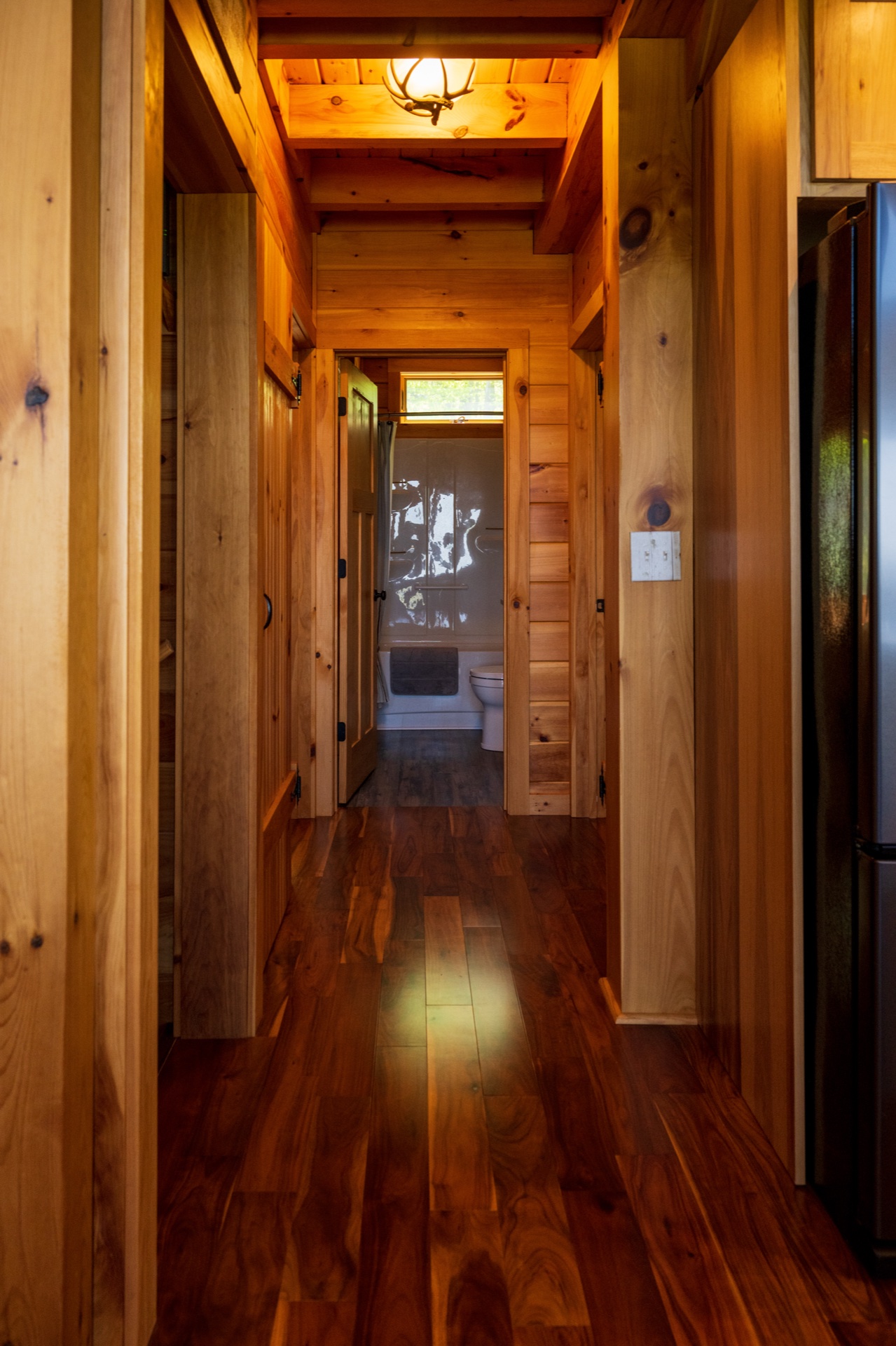 Ossipee hallway with antler light fixture looking toward an open bathroom