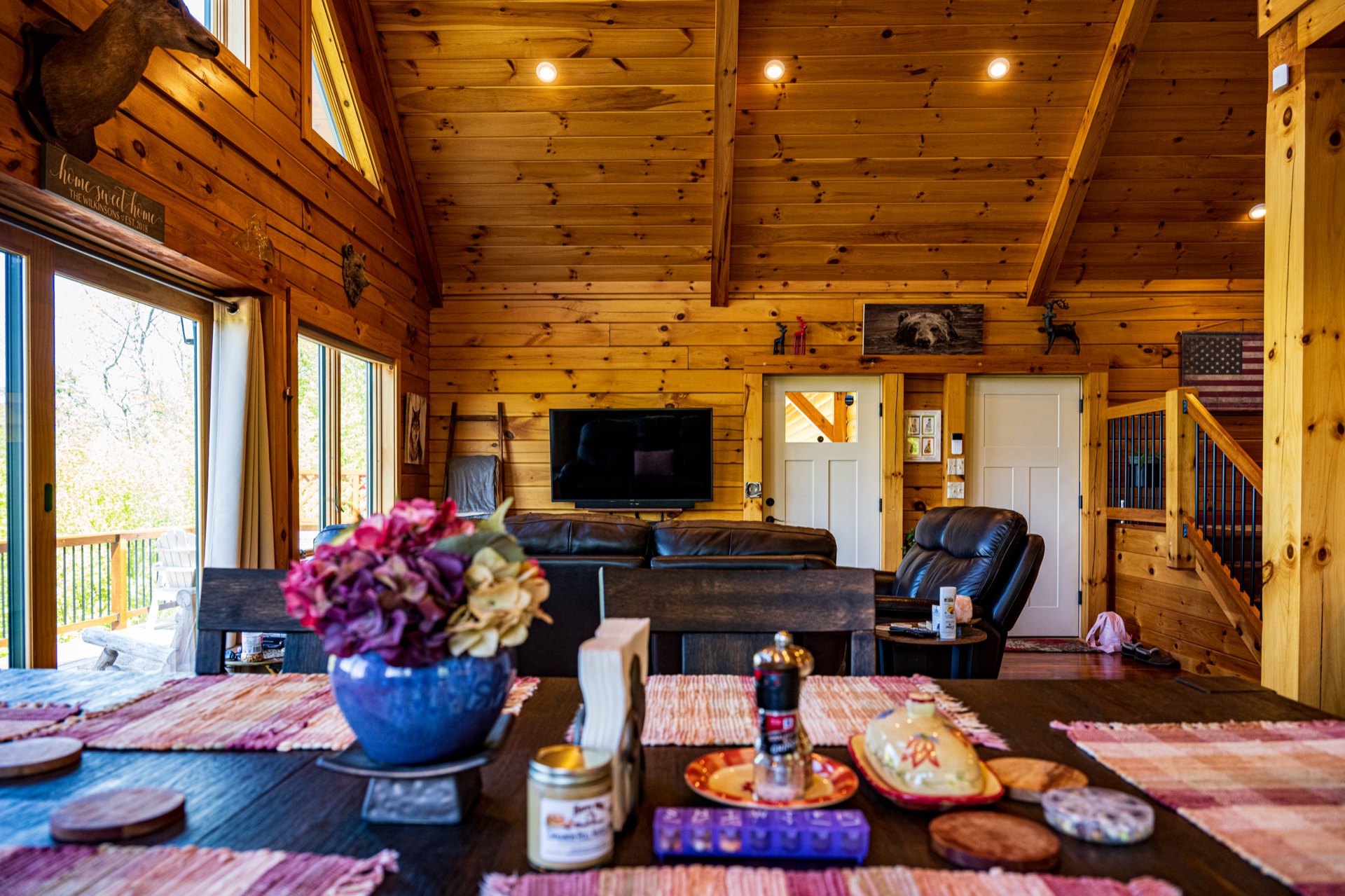 Ossipee open living and dining area with leather couches and chalet windows