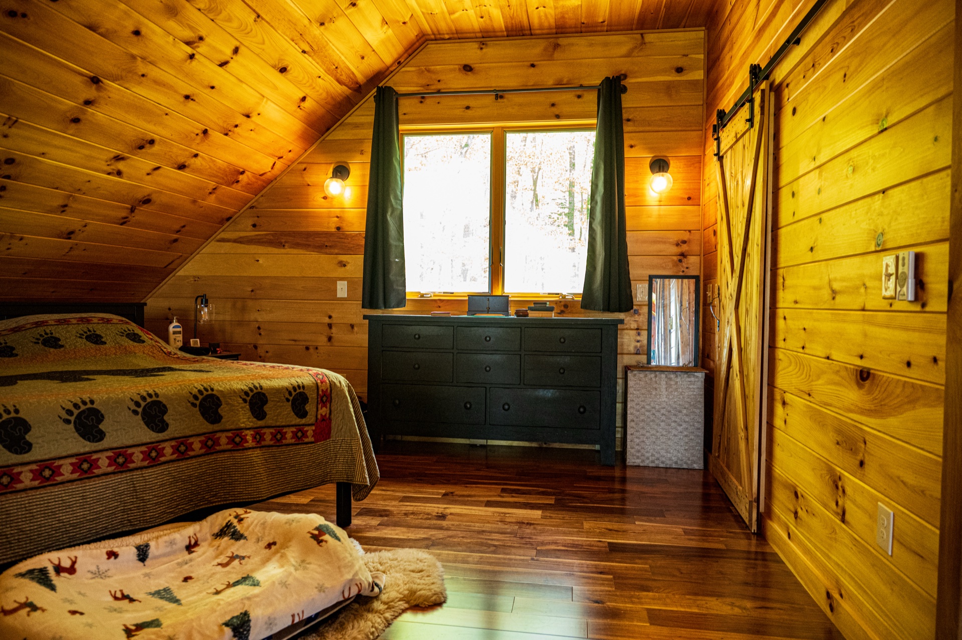 Ossipee loft bedroom with green curtains and sliding barn door