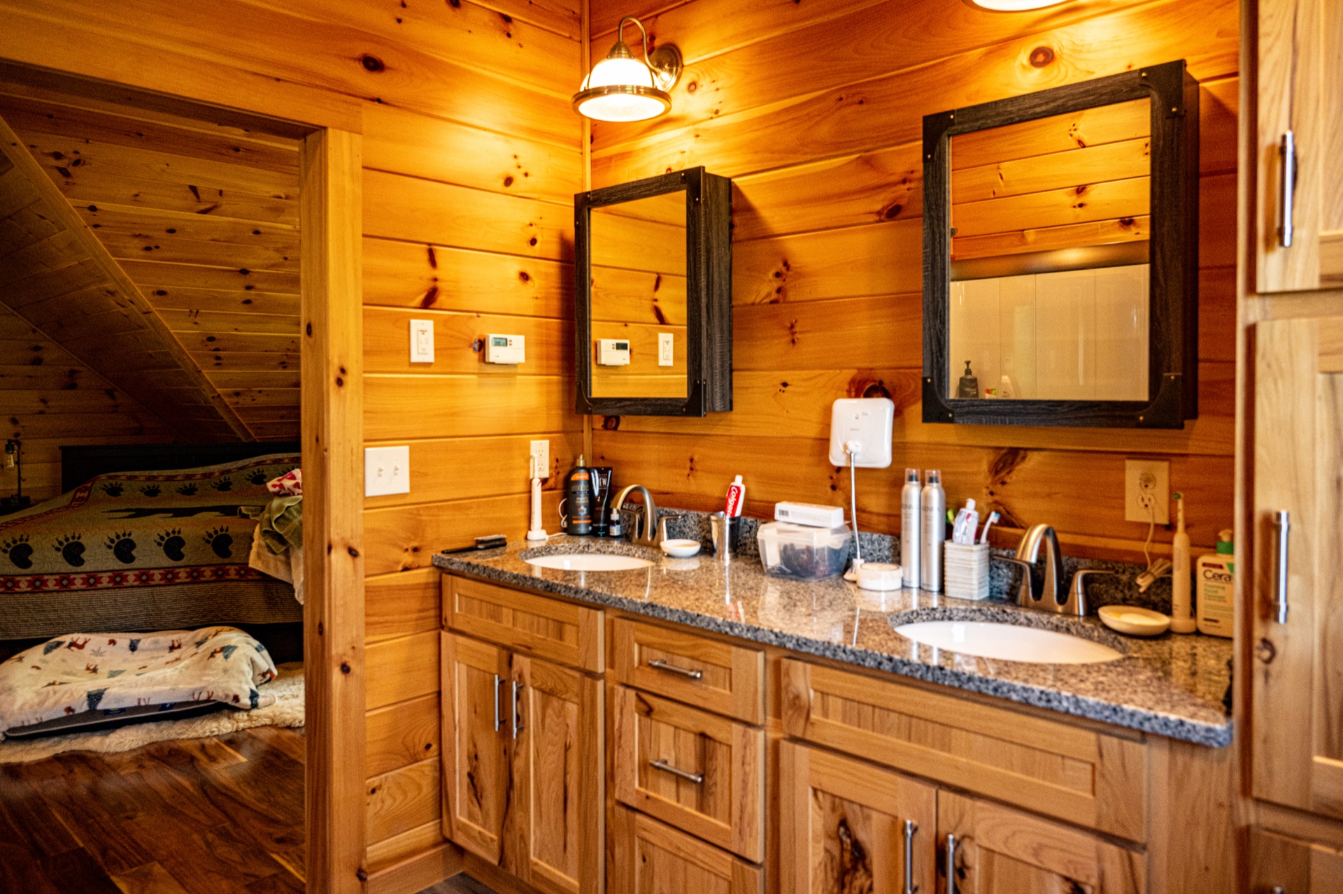 Ossipee master bathroom with double vanity, two mirrors, and view into the master bedroom