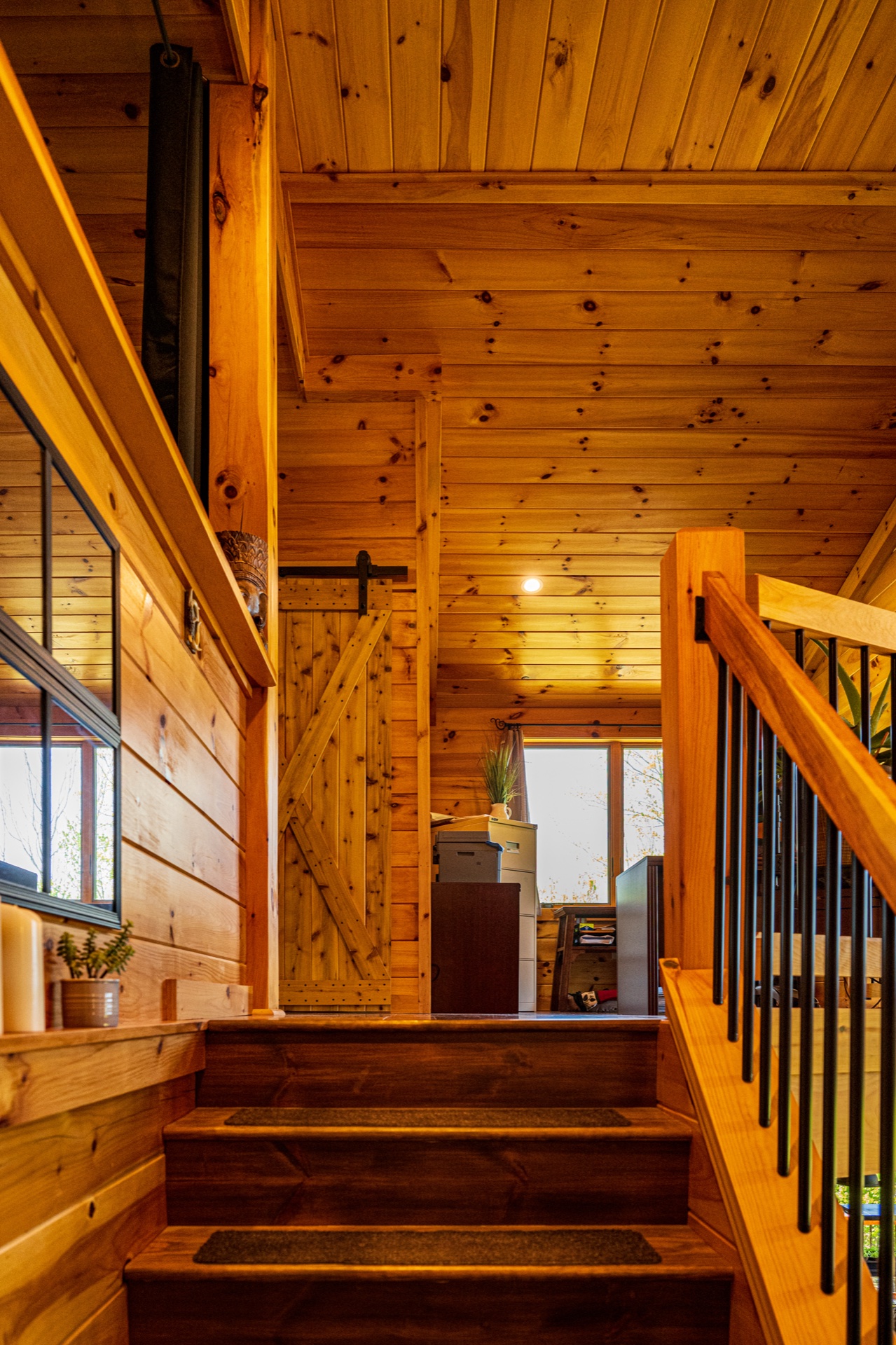 Ossipee staircase landing with sliding barn door and balcony railing