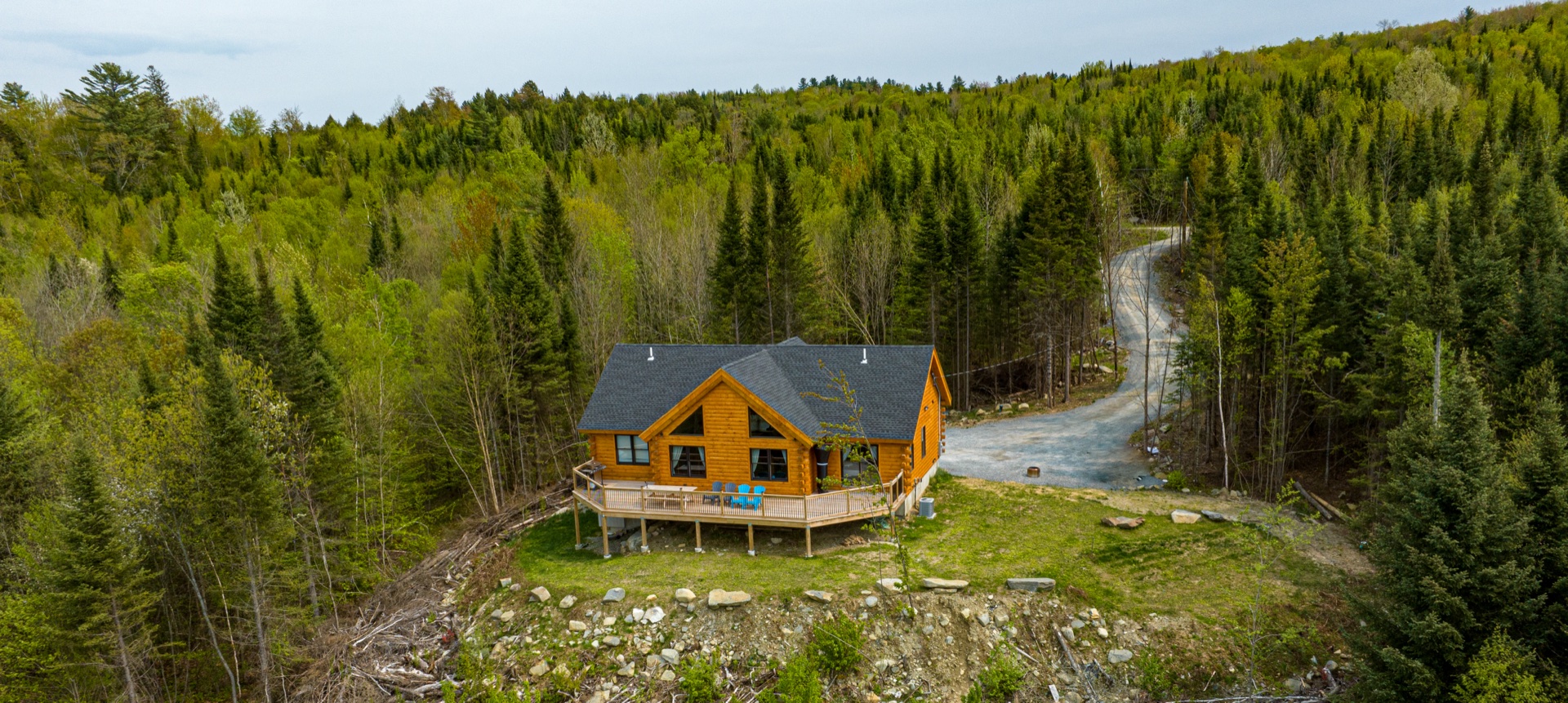Aerial view of the Sunapee log home with driveway curving up to the property