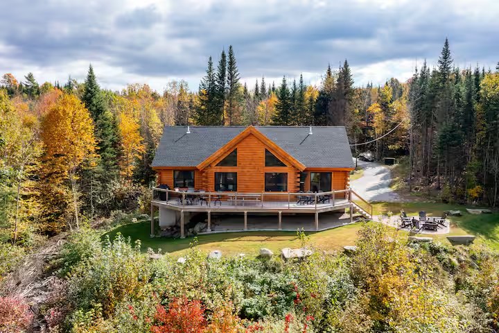 Aerial view of the Sunapee log home with peak fall foliage surrounding the property
