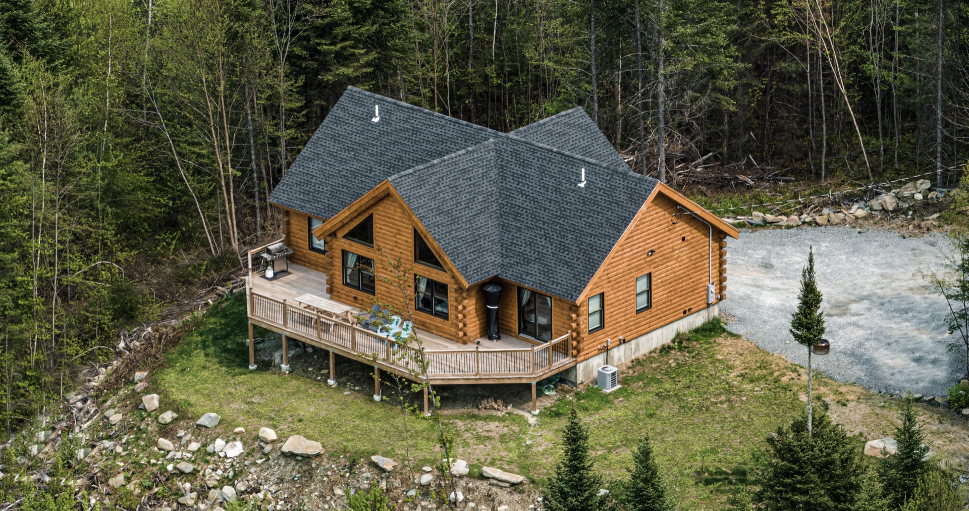 Overhead drone view of the Sunapee log home roofline and deck