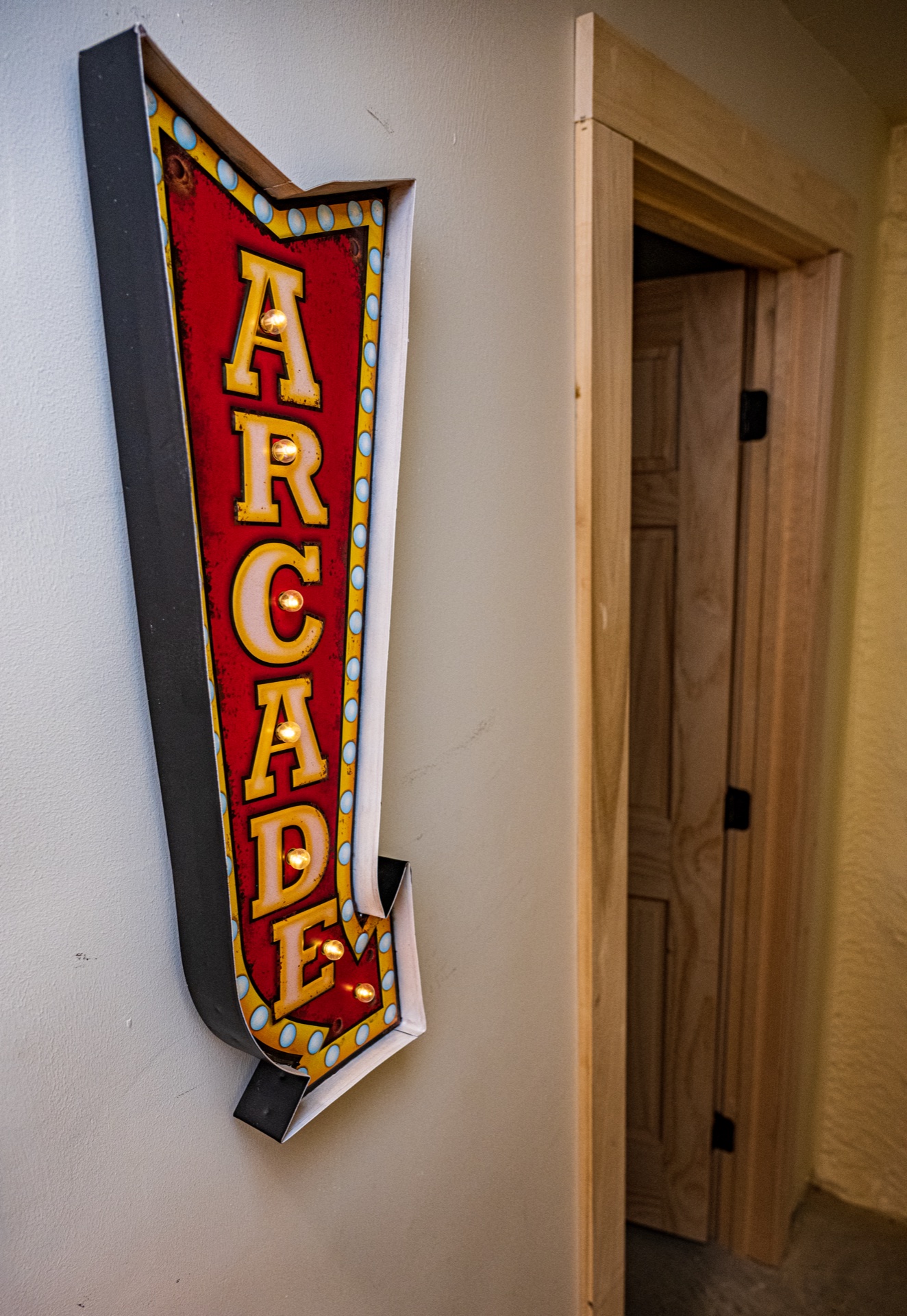 Vintage marquee Arcade sign next to a pine door