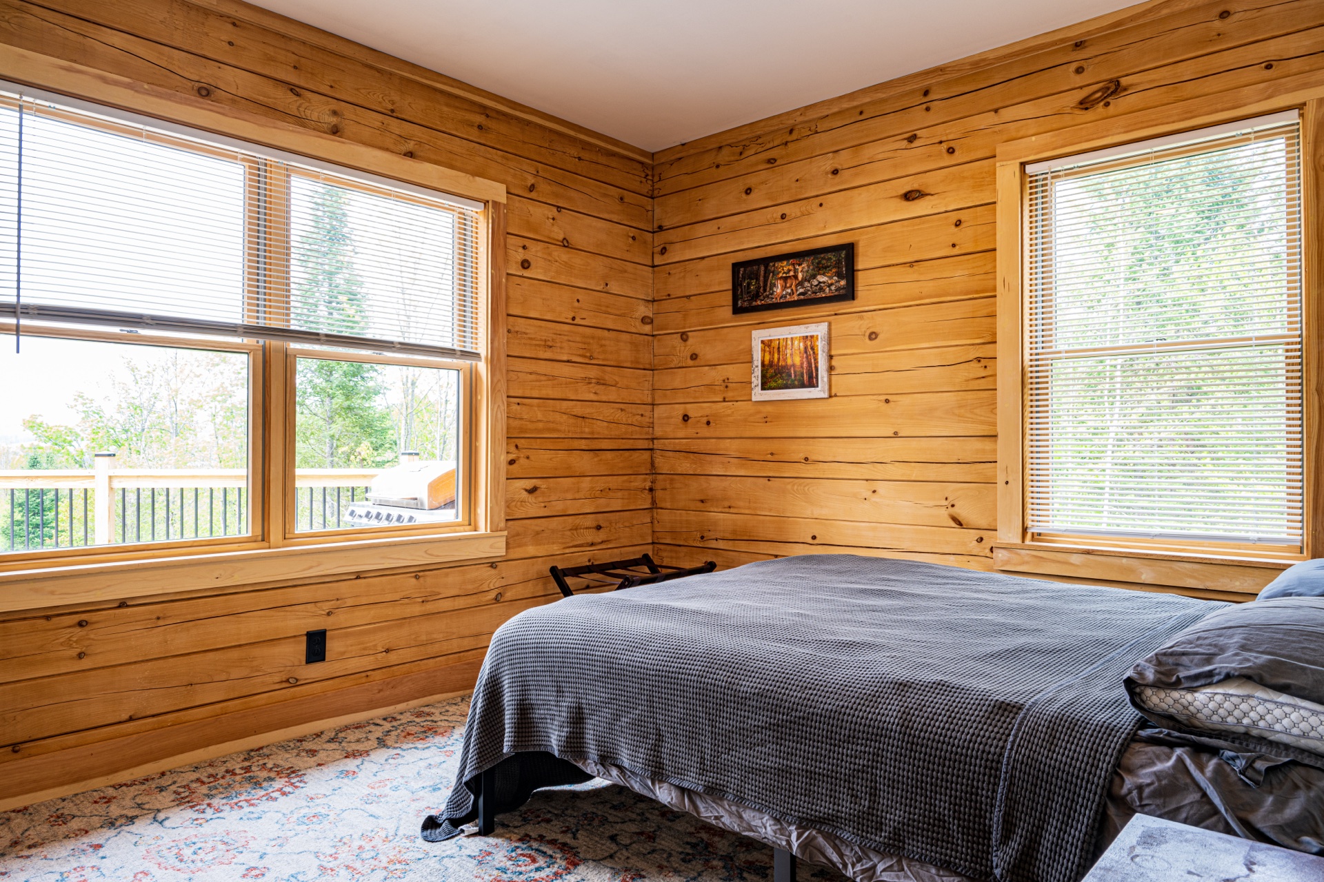 Sunapee bedroom with pine walls and windows opening onto the deck
