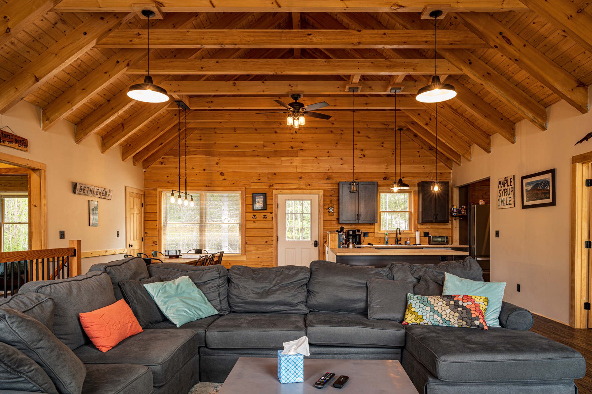 Sunapee great room with sectional couch, exposed beams, and view to the kitchen