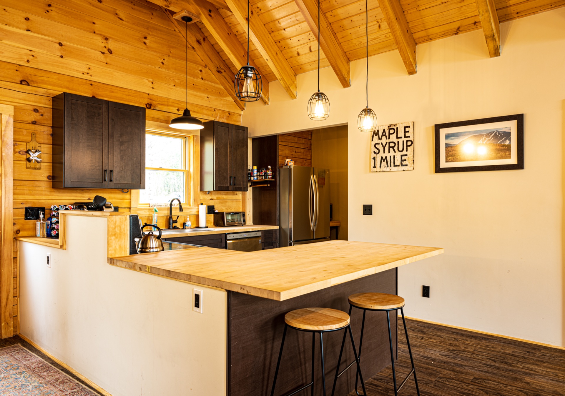 Sunapee kitchen with butcher block island, dark cabinets, and pendant lighting