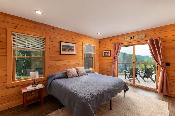 Sunapee master bedroom with sliding glass door opening directly to the deck and mountain view