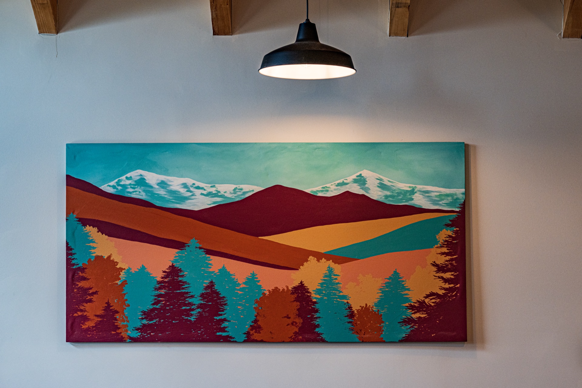 Large stylized mountain landscape painting on the wall of the Sunapee