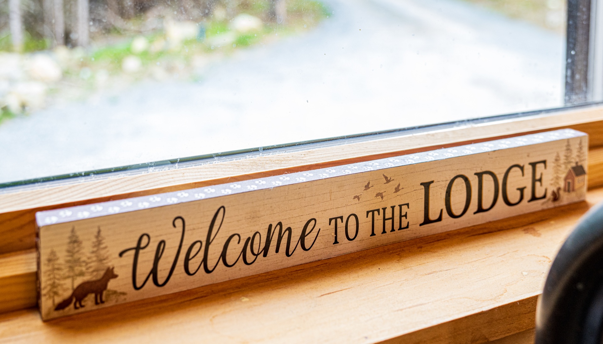 Welcome to the Lodge wooden sign on a windowsill at the Sunapee