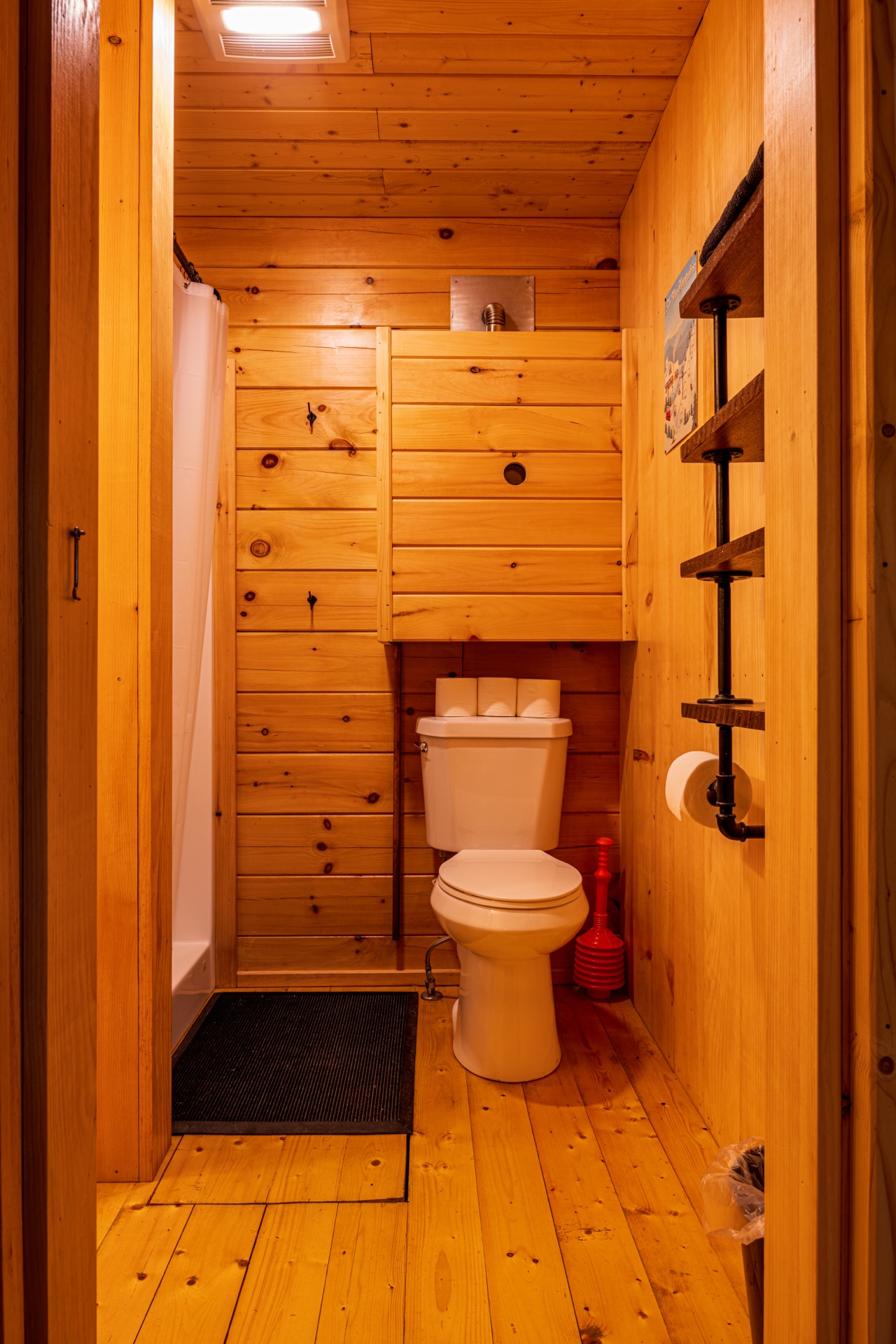Tiny log home bathroom with shower and pine walls