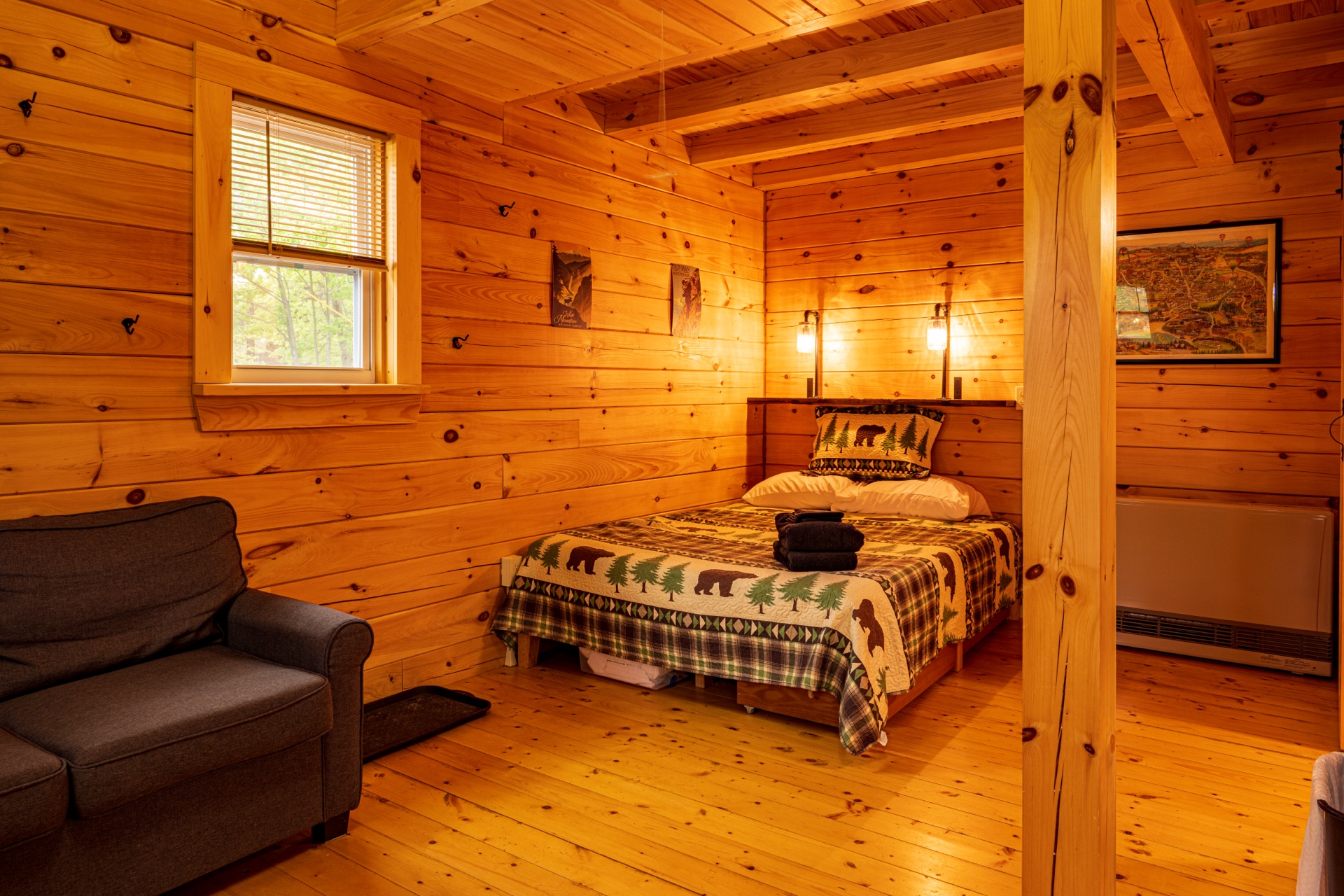 Tiny log home bedroom with bear and pine quilt and pine walls