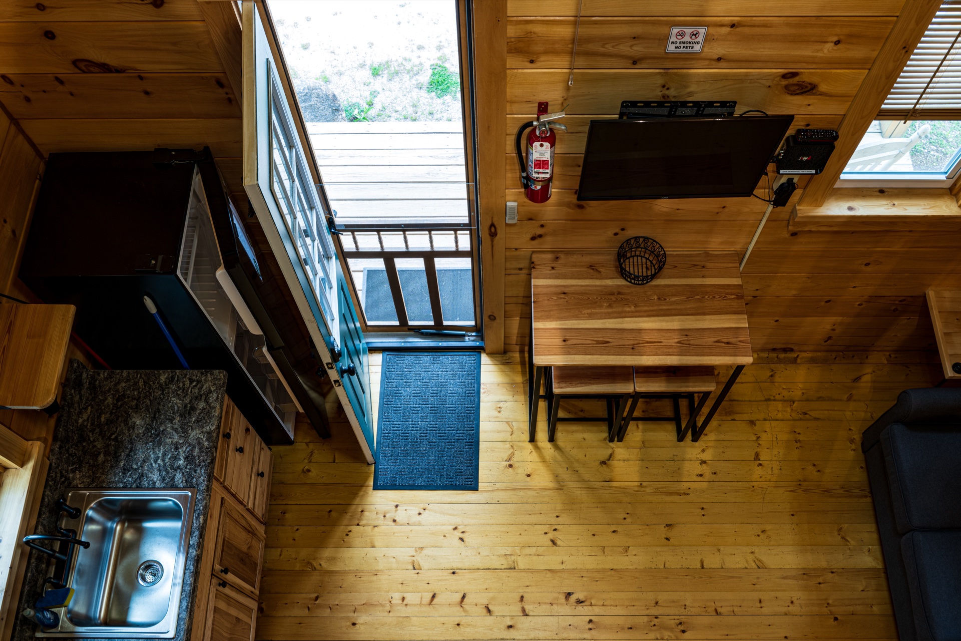 Tiny log home overhead view of the kitchen and dining area from the loft